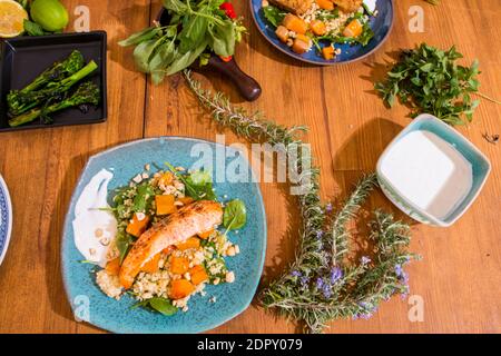 Gegrilltes Gemüse und gesunde Gerichte auf einem schicken Holztisch. Mediterrane Gerichte mit Spargel, Tofu, Seitan und Halloumi-Käse. Gluten Stockfoto