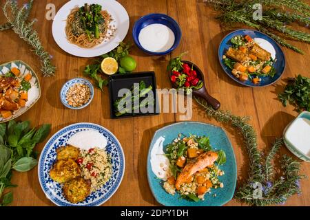 Gegrilltes Gemüse und gesunde Gerichte auf einem schicken Holztisch. Mediterrane Gerichte mit Spargel, Tofu, Seitan und Halloumi-Käse. Gluten Stockfoto