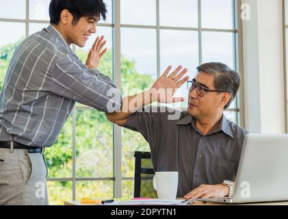Asian Senior und junge Geschäftsmann Begrüßung einander im Büro. Glückliche alte und Junior zwei Geschäftsleute begrüßen Touch Hand, Gruß und Partnerschaft Stockfoto