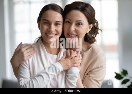 Kopf erschossen Porträt lächelnd mittleren Alters Mutter umarmt erwachsenen Tochter Stockfoto
