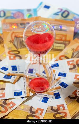 Sanduhr auf einem Hintergrund von 50 und 20 Euro Banknoten. Konzepte von Investitionen, Rentabilität, Rentengeld und Geldfluss im Laufe der Zeit Stockfoto