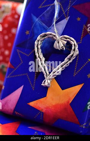 Nahaufnahme von bunten weihnachtsgeschenken mit einem silberfarbenen Herz Stockfoto
