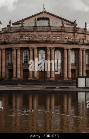 07. März 2020 Stuttgart, Deutschland - Vorderansicht des berühmten historischen Stuttgarter Opernhauses nach Plänen des Architekten Max Littmann mit kleinem Eckensee Stockfoto