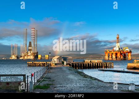 CROMARTY SCHWARZ ISLE HALBINSEL SCHOTTLAND REGENBOGENFARBEN ÜBER HAFEN UND ÖLPLATTFORMEN ODER BOHRINSELN IM CROMARTY FIRTH Stockfoto