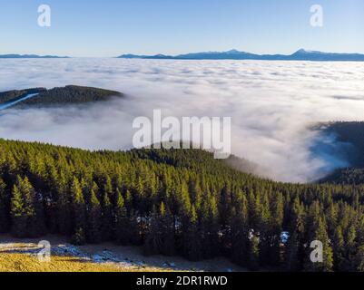 Meer der Wolken und malerische Berge oben. Schöne Karpaten im frühen Winter oder Herbst Luftaufnahme Stockfoto