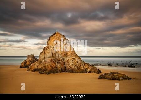 Rock am Gillards Beach in einer bunten Morgenstimmung. Stockfoto