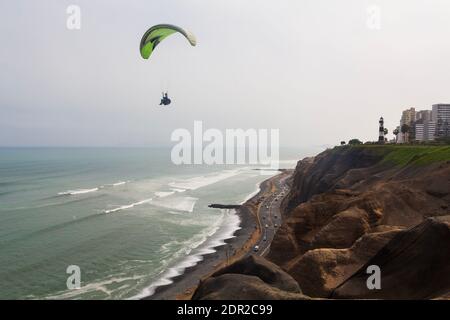 Lima, Peru - 19. Juni 2015: Gleitschirme segeln vor den Klippen von Miraflores in der Nähe des La Marina Leuchtturms über den Pazifik. Stockfoto