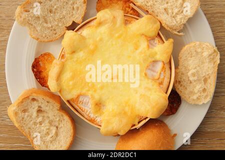 Ein im Ofen gebackener Camembert mit Brötchen Stockfoto