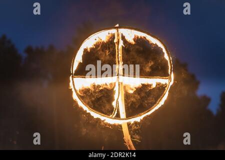 Brennendes Symbol der Sonne, ein Sonnenkreuz oder Sonnenrad bei heidnischer Nachstellung der Kupala-Nacht, in Polen Noc Kupaly genannt. Stockfoto