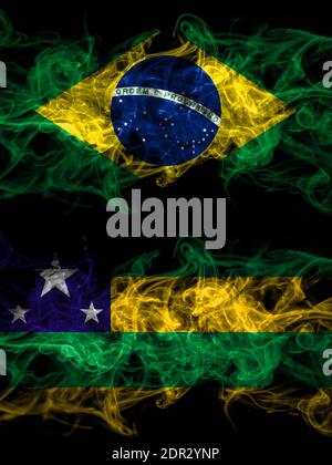 Brasilien, Brasilianisch vs. Brasilien, Brasilianisch, Sergipe Smoky Mystic Flags nebeneinander platziert. Dick farbige seidig abstrakte Rauchfahnen. Stockfoto