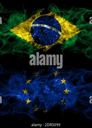 Brasilien, Brasilien vs Europa, Europa, Europäische Union rauchige mystische Flaggen nebeneinander platziert. Dick farbige seidig abstrakte Rauchfahnen. Stockfoto
