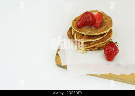 Pfannkuchen mit Ahornsirup mit geschnittenen Erdbeeren gekrönt Stockfoto