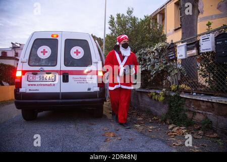 Rom, Italien. Dezember 2020. (12/19/2020) FREIWILLIGER des italienischen Roten Kreuzes als Weihnachtsmann bekleidet bringt Geschenke an arme Familien in Municipio 5 in Rom (Foto von Matteo Nardone/Pacific Press/Sipa USA) Kredit: SIPA USA/Alamy Live News Stockfoto