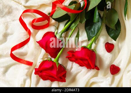Valentinstag Überraschung. Rote Rosen und Herzen auf dem Bett. Draufsicht flach liegend. Stockfoto