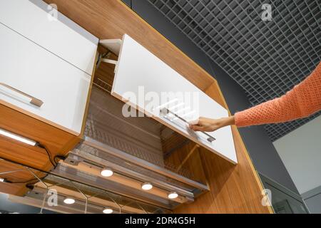 Frau Hand öffnet eine moderne stilvolle weiße Schale Trocknungsschrank mit einer Tür öffnen Nahaufnahme. Moderne, stilvolle Küche Stockfoto