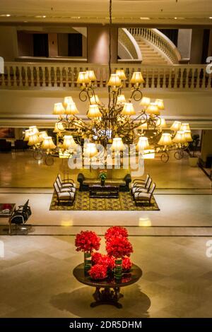 Die Inneneinrichtung einer wunderschönen Lobby mit roten Blumen Und ein großer Kronleuchter im Mittelpunkt Stockfoto