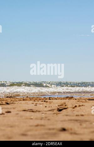 Low-Angle-Aufnahme des Strandes mit Blick auf Frinton mit geringer Schärfentiefe Fokus auf Meer. Walton on the Naze, Essex, Großbritannien Stockfoto
