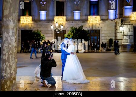 Valencia, Valencia, Spanien. Dezember 2020. Ein Fotograf, der während Weihnachten in Valencia ein frisch verheiratetes Paar auf dem Rathausplatz fotografiert.die Valencianische Gemeinschaft wird die neuen restriktiven Maßnahmen für dieses Weihnachten fortsetzen, die am 21. Dezember bis zum 15. Januar in Kraft treten werden.die Treffen werden nicht mehr als 6 Personen überschreiten und es wird sein Es ist möglich, bis 11 Uhr auf der Straße zu sein, außer am 24. Und 31., die bis 12 Uhr stattfinden wird. In gleicher Weise wird die Randgrenze in der gesamten Gemeinde Valencia fortgeführt. Valencia, Den 20. Dezember 2020. (Bild: © Xi Stockfoto