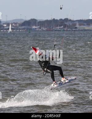 Sandbanks, Großbritannien. Dezember 2020. Ein Kitesurfer hält seinen Kopf warm mit einem weihnachtsmütze, wie er das Beste aus windigen Bedingungen am letzten Wochenende vor Weihnachten in Poole Hafen bei Sandbanks in Dorset macht. Kredit: Richard Crease/Alamy Live News Stockfoto