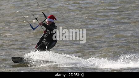 Sandbanks, Großbritannien. Dezember 2020. Ein Kitesurfer hält seinen Kopf warm mit einem weihnachtsmütze, wie er das Beste aus windigen Bedingungen am letzten Wochenende vor Weihnachten in Poole Hafen bei Sandbanks in Dorset macht. Kredit: Richard Crease/Alamy Live News Stockfoto