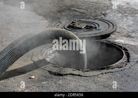 Schlauch, der an einen Tank am Boden angeschlossen ist und das Heizöl abführt, da das Produkt eine hohe Temperatur hat, treten Dämpfe durch die Entlüftung aus. Stockfoto