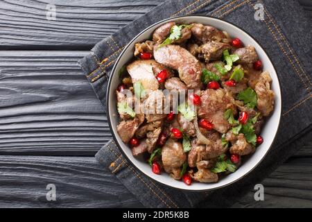 Hausgemachte Kuchmachi aus Hühnerleber, Herzen und Muskelmagen mit Zwiebeln, Walnüssen und Granatapfel close-up in einer Schüssel auf dem Tisch. Horizontale Spitze V Stockfoto