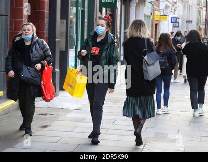 Zwei Frauen mit Gesichtsmasken tragen Einkaufstaschen entlang der Oxford Street.Last-Minute-Weihnachtseinkäufe in Londons Oxford Street und Regent Street am Vorabend, in Tier 4-Lockdown gestürzt zu werden, mit allen nicht notwendigen Einzelhandelsgeschäften eingestellt, um zu schließen. Stockfoto