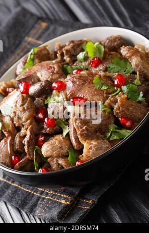 Kuchmachi georgischen Gericht aus Innereien mit Gewürzen, Zwiebeln und Granatapfel Nahaufnahme in einer Schüssel auf dem Tisch. Vertikal Stockfoto