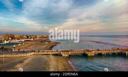 Sonnenuntergang Rom Luftaufnahme in Ostia Lido Strand über blauem Meer und braunen Sandstrand, schöne Küste Linie mit Blick auf Fußgängerpier ein Wahrzeichen von To Stockfoto