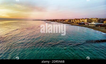 Sonnenuntergang Rom Luftaufnahme in Ostia Lido Strand über blauem Satin Meer und braunem Sandstrand, schöne Küste und Promenade ein Wahrzeichen der Touristen und Cit Stockfoto