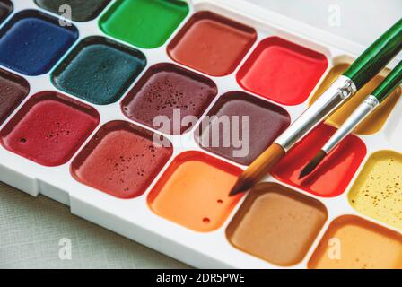 Box mit neuen Aquarellfarben und zwei Pinsel Nahaufnahme Stockfoto