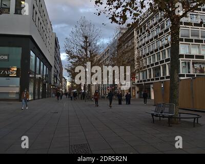 Menschen mit Gesichtsmasken wandern in der beliebten Einkaufsstraße Königstraße in der Innenstadt während der Covid-19-Sperre mit geschlossenen Geschäften und Dekoration. Stockfoto