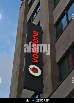 Großes Vodafone (Telekommunikationsunternehmen)-Werbeschild mit Firmenlogo an der Gebäudefassade über der Filiale in der Einkaufsstraße Königstraße. Stockfoto