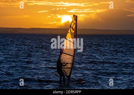 Chalkwell Beach, Southend on Sea, Essex, Großbritannien. Dezember 2020. Der erste Tag des COVID Alert Tier 4 in Southend on Sea endete hell, aber kalt, mit dem Sonnenuntergang hinter einem Windsurfer draußen an der Themse Mündung Stockfoto