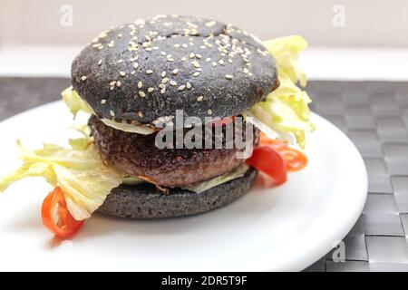 Wagyu Burger mit schwarzen Brötchen Stockfoto