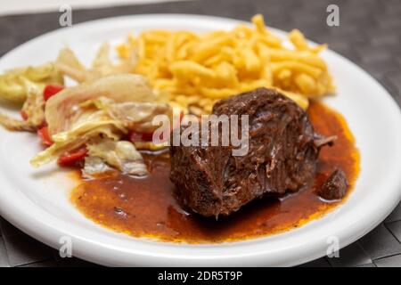 Ochsenbacken mit Nudeln und Salat Stockfoto