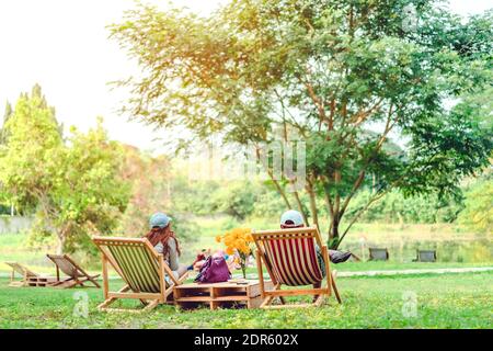 Glück Paar auf einem Sommerurlaub sitzen auf Stühlen im öffentlichen Park zu entspannen. Stockfoto