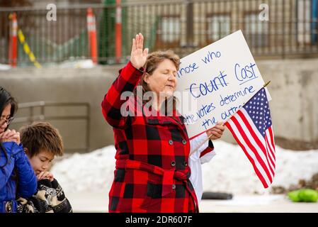 Helena, Montana / Nov 7, 2020: Frau und Kinder beten Hand an Donald Trumps Stop the Steal Rallye mit amerikanischer Flagge und Zeichen über cou Stockfoto