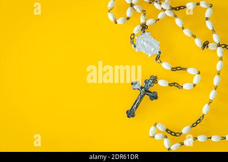 Christlicher Rosenkranz auf gelbem Hintergrund. Für Text platzieren Stockfoto