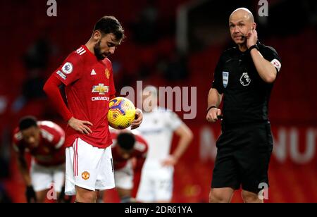 Bruno Fernandes von Manchester United (links) wartet, während Schiedsrichter Anthony Taylor mit VAR spricht, bevor er während des Premier League-Spiels in Old Trafford, Manchester, den Elfmeterstoß eingeht. Stockfoto