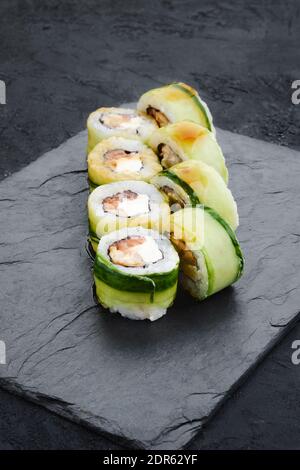 Brötchen mit Aal, Gurke und Thunfisch auf Schieferteller Stockfoto