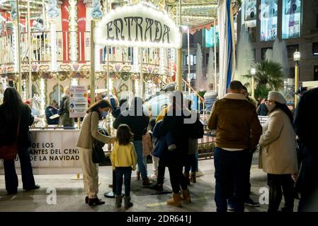 Valencia, Spanien. Dezember 2020. Familien tragen Gesichtsmasken als Vorsichtsmaßnahme gegen die Ausbreitung von covid-19 in der Warteschlange des Karussells.während der Weihnachtszeit. Kredit: Xisco Navarro/SOPA Images/ZUMA Wire/Alamy Live Nachrichten Stockfoto