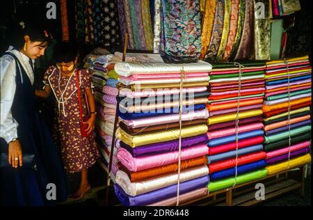 Große Stapel von bunten Textilien auf dem Bogyoke Aung San Markt, Yangon, Myanmar. Juli 1999 Stockfoto