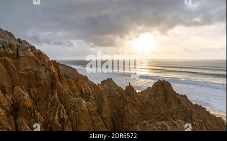 Viele bizarre erodierte Sanddünen am Atlantischen Ozean mit Wellen Rollen bei Sonnenuntergang ein Stockfoto