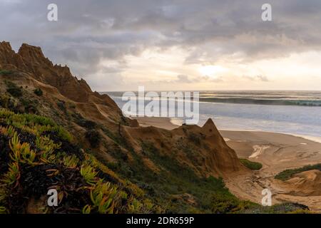 Viele bizarre erodierte Sanddünen am Atlantischen Ozean mit Wellen Rollen bei Sonnenuntergang ein Stockfoto
