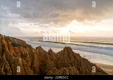 Viele bizarre erodierte Sanddünen am Atlantischen Ozean mit Wellen Rollen bei Sonnenuntergang ein Stockfoto