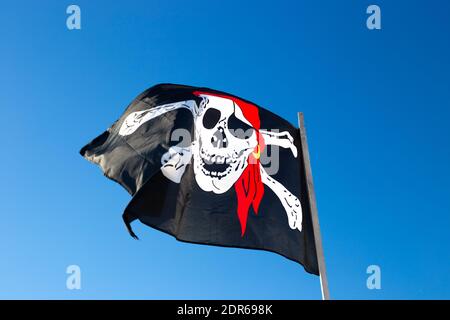 Piratenflagge fliegt gegen den blauen Himmel. Marine Utensilien Stockfoto