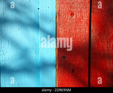 Textur von gebrauchten Holzplanken rot und blau lackiert Stockfoto