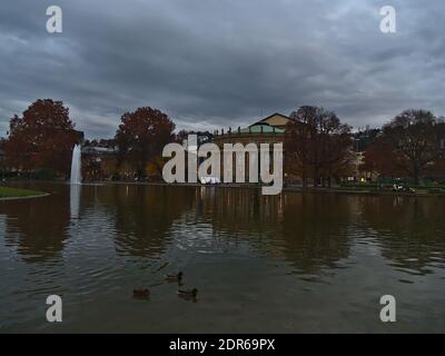 Schöne Aussicht auf Enten schwimmen in kleinen See Eckensee mit Wasserbrunnen in der Innenstadt von Stuttgart, Baden-Württemberg, Deutschland mit Oper. Stockfoto