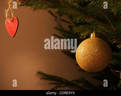 Weihnachtsdekoration Hintergrund, mit einem Ball und ein Herz hängen auf einem Tannenzweig Stockfoto